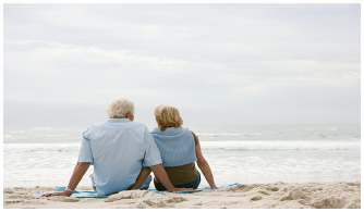 Prepared for retirement. Photo of a couple in their seventies sitting on sand looking out towards the ocean during retirement.