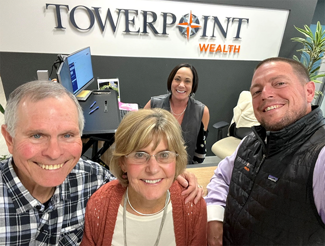 Joseph, Dan, and Sue in front of Michelle behind the desk with the Towerpoint Wealth
