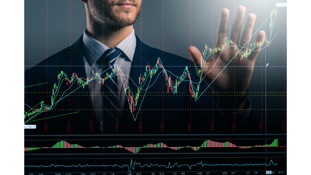Businessman in a suit analyzing a virtual stock market chart with candlestick patterns and trend lines projected in front of him.